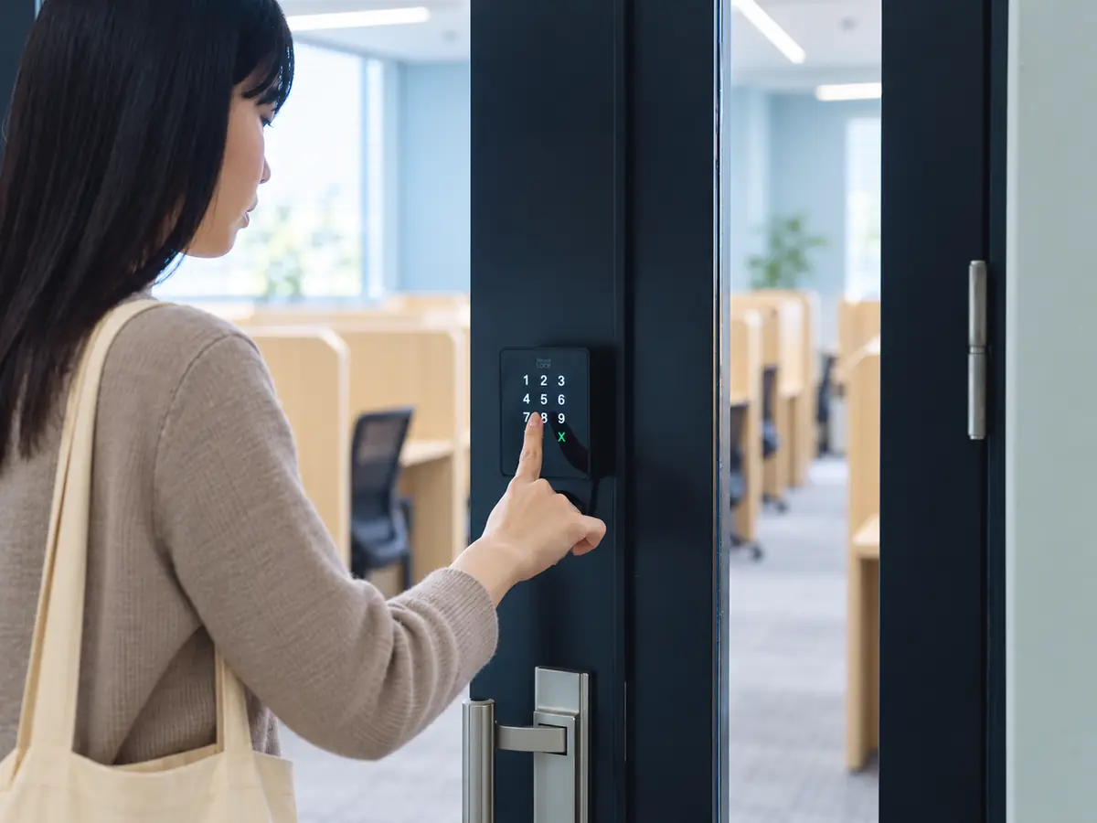 入口のテンキーで暗証番号を入力する利用者